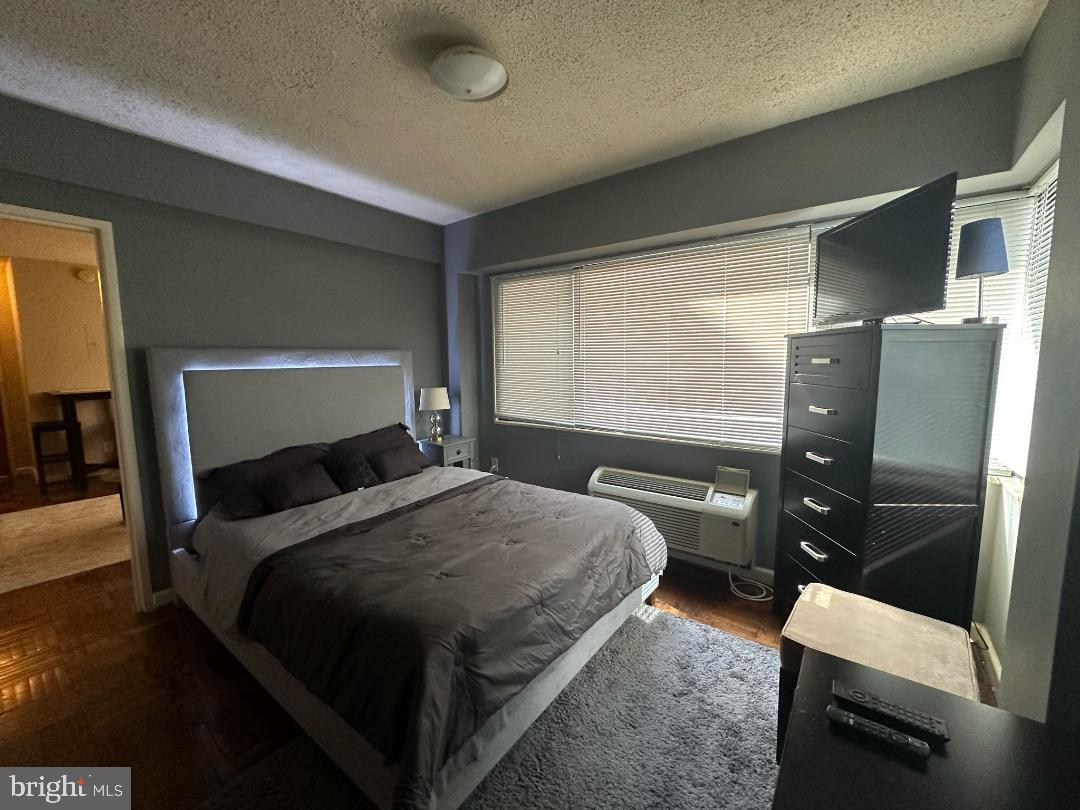 2141 I Street Northwest, Unit 615 Washington, DC 20037 - Photo 7 of 16 a bedroom with a bed and wooden floor