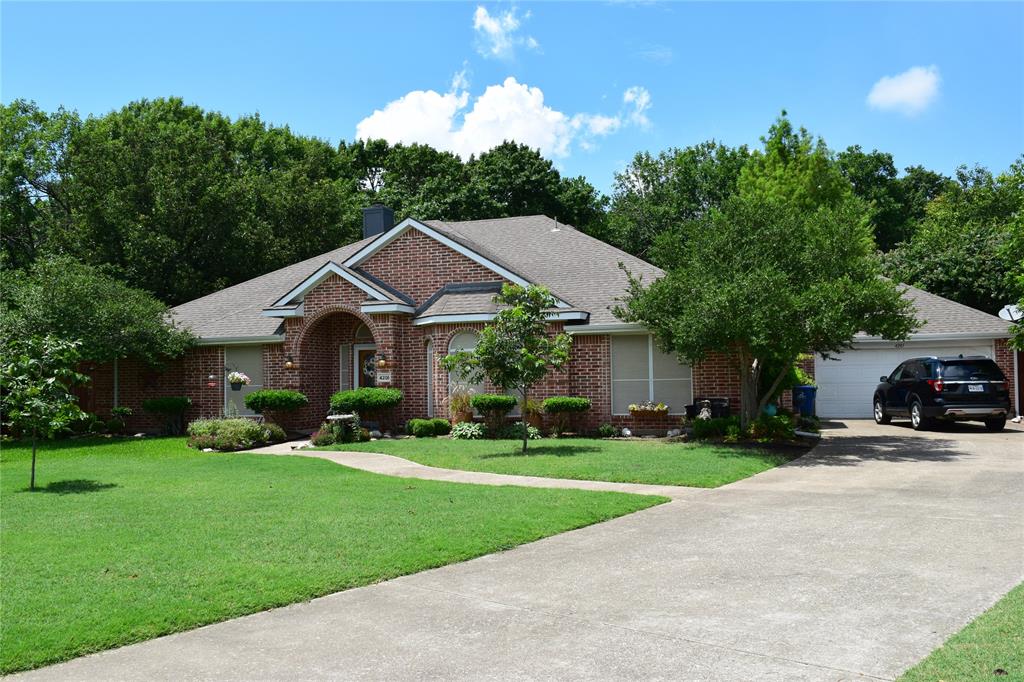 4201 Glistening Spring Rowlett, TX 75088 - Photo 33 of 33 Brick facade residence featuring an arched entryway, gabled roofline, and attached two-car garage