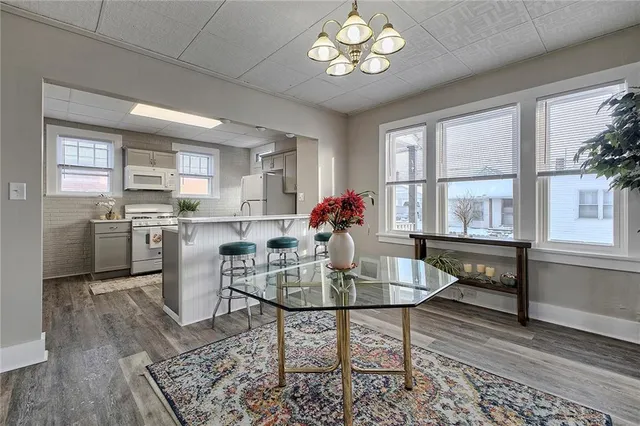 a kitchen with a dining table chairs refrigerator and cabinets