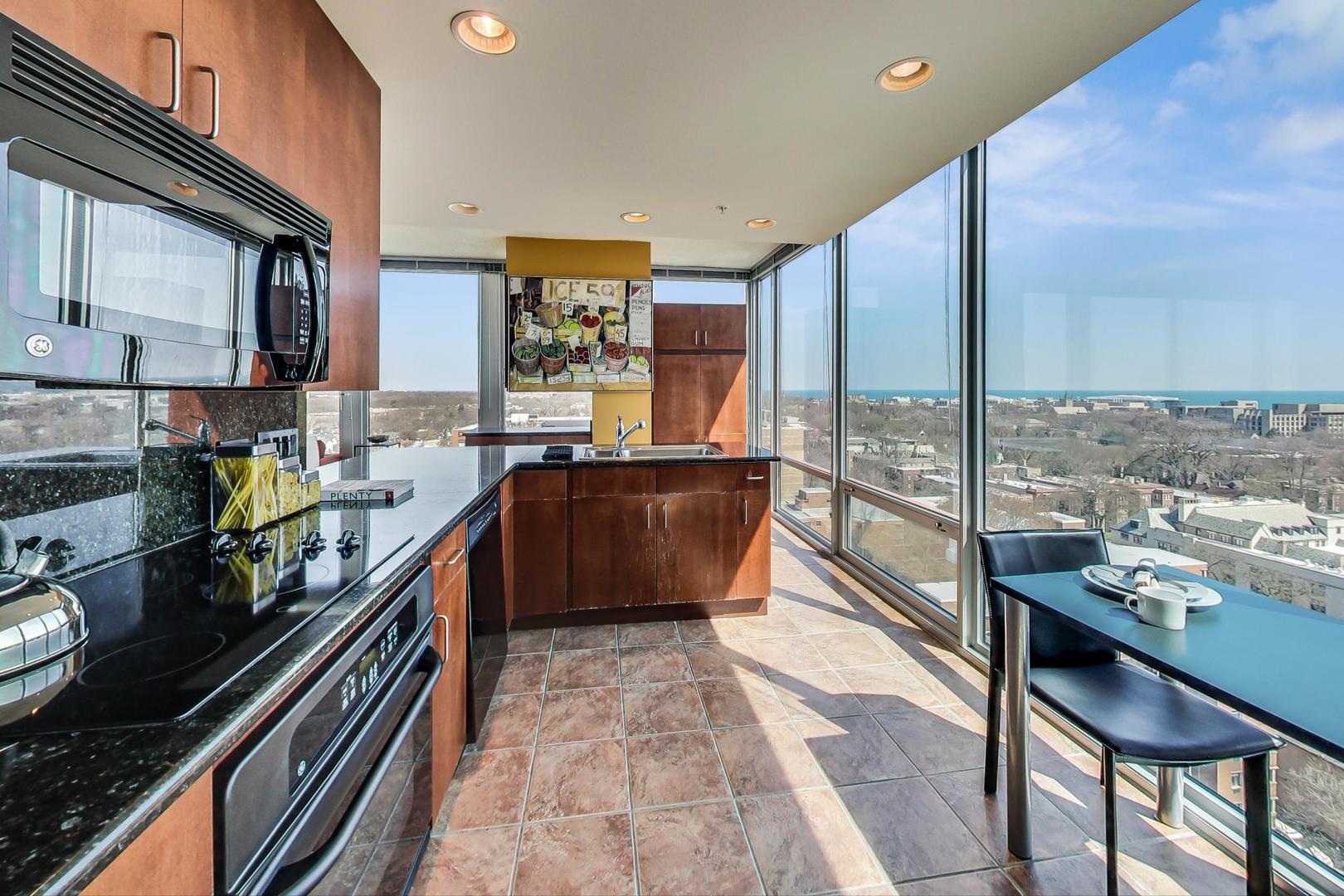 800 Elgin Road, Unit PH02 Evanston, IL 60201 - Photo 13 of 43 a kitchen with stainless steel appliances kitchen island granite countertop a stove a sink and a granite counter top