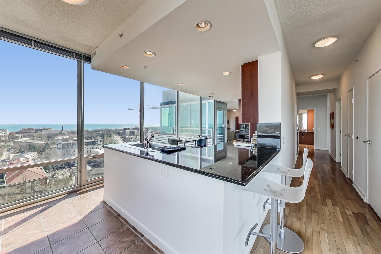 800 Elgin Road, Unit PH02 Evanston, IL 60201 - Photo 14 of 43 a kitchen with stainless steel appliances kitchen island granite countertop a sink and cabinets