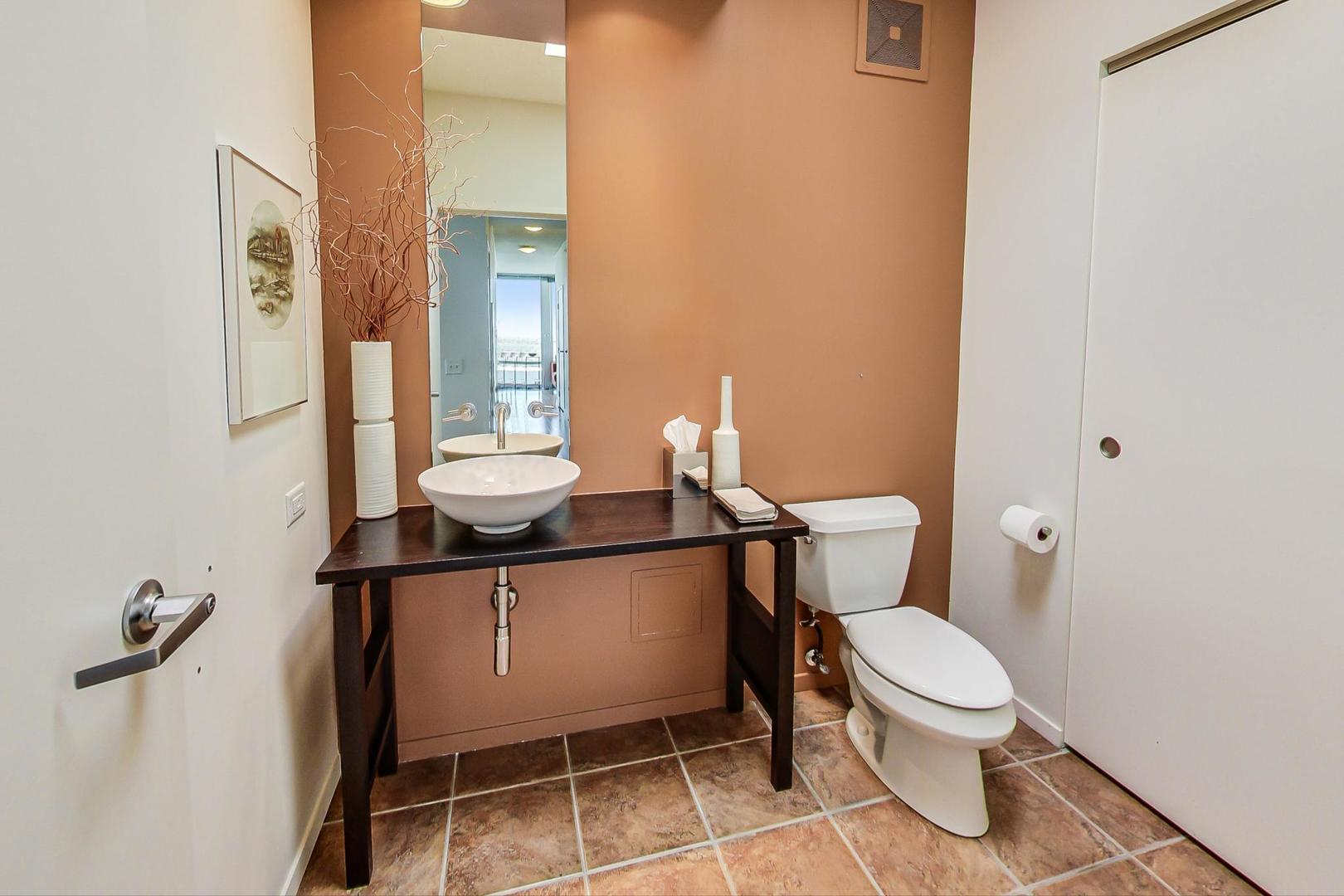800 Elgin Road, Unit PH02 Evanston, IL 60201 - Photo 17 of 43 a bathroom with a toilet a sink and mirror