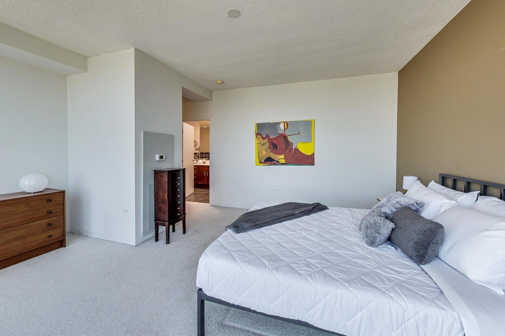 800 Elgin Road, Unit PH02 Evanston, IL 60201 - Photo 24 of 43 a bedroom with a bed and a dresser