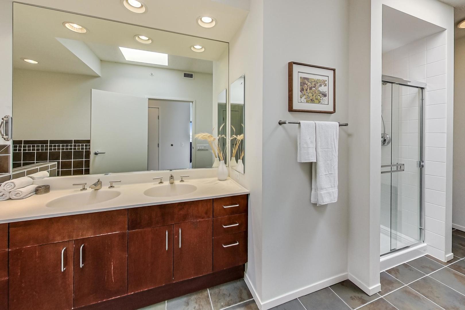 800 Elgin Road, Unit PH02 Evanston, IL 60201 - Photo 27 of 43 a bathroom with a granite countertop sink a mirror and a shower