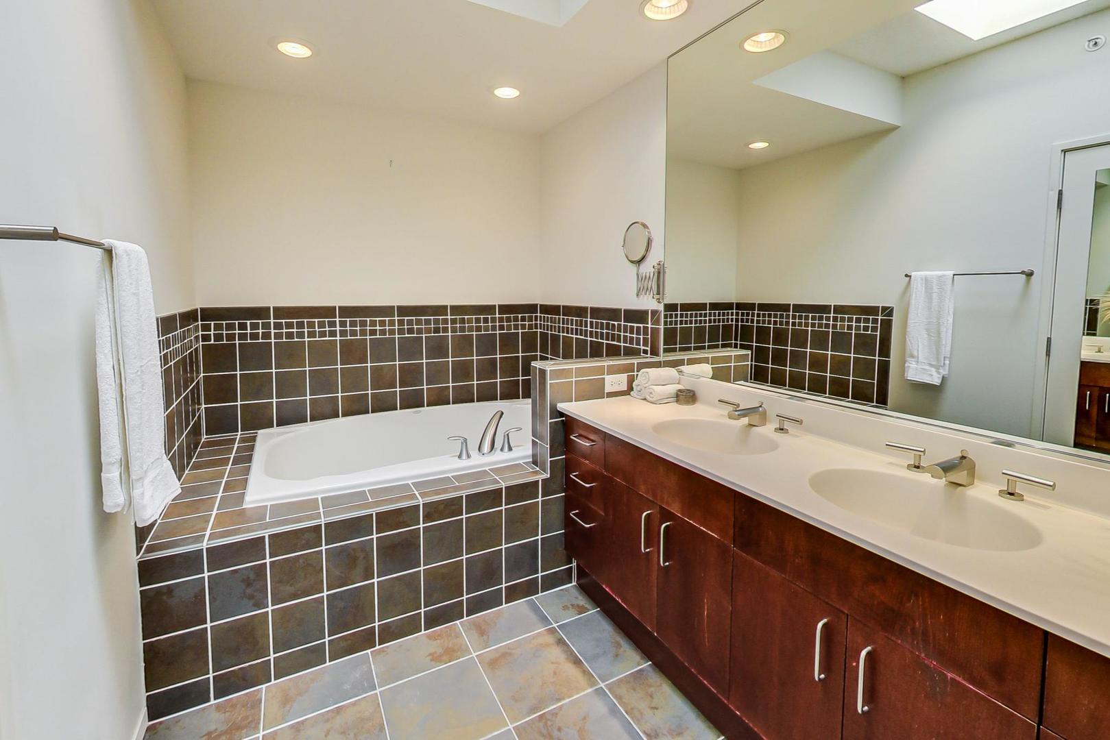 800 Elgin Road, Unit PH02 Evanston, IL 60201 - Photo 28 of 43 a bathroom with a double vanity sink a mirror and a