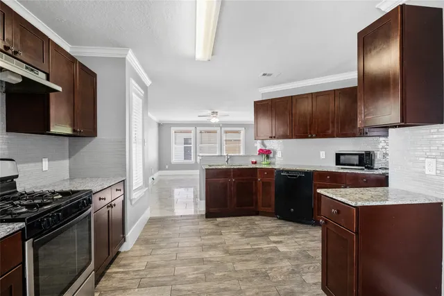 a kitchen with stainless steel appliances granite countertop a stove a sink dishwasher a refrigerator and a microwave oven