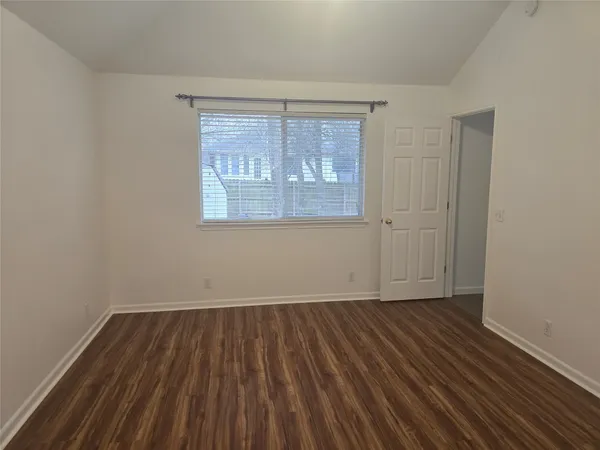 a view of a room with wooden floor fan and window