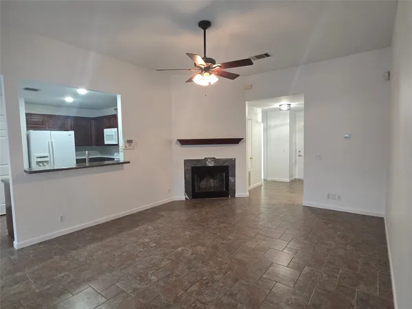 a view of a livingroom with a ceiling fan a fireplace and a ceiling fan