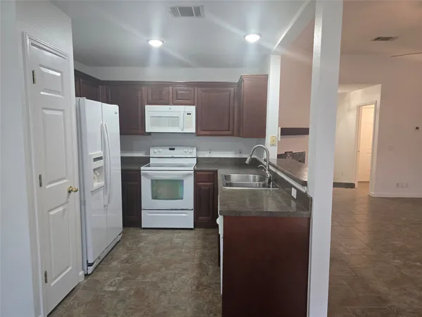 a kitchen with stainless steel appliances granite countertop a refrigerator stove and sink