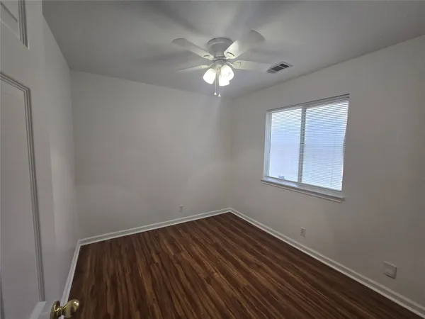 a view of wooden floor and chandelier fan in a room