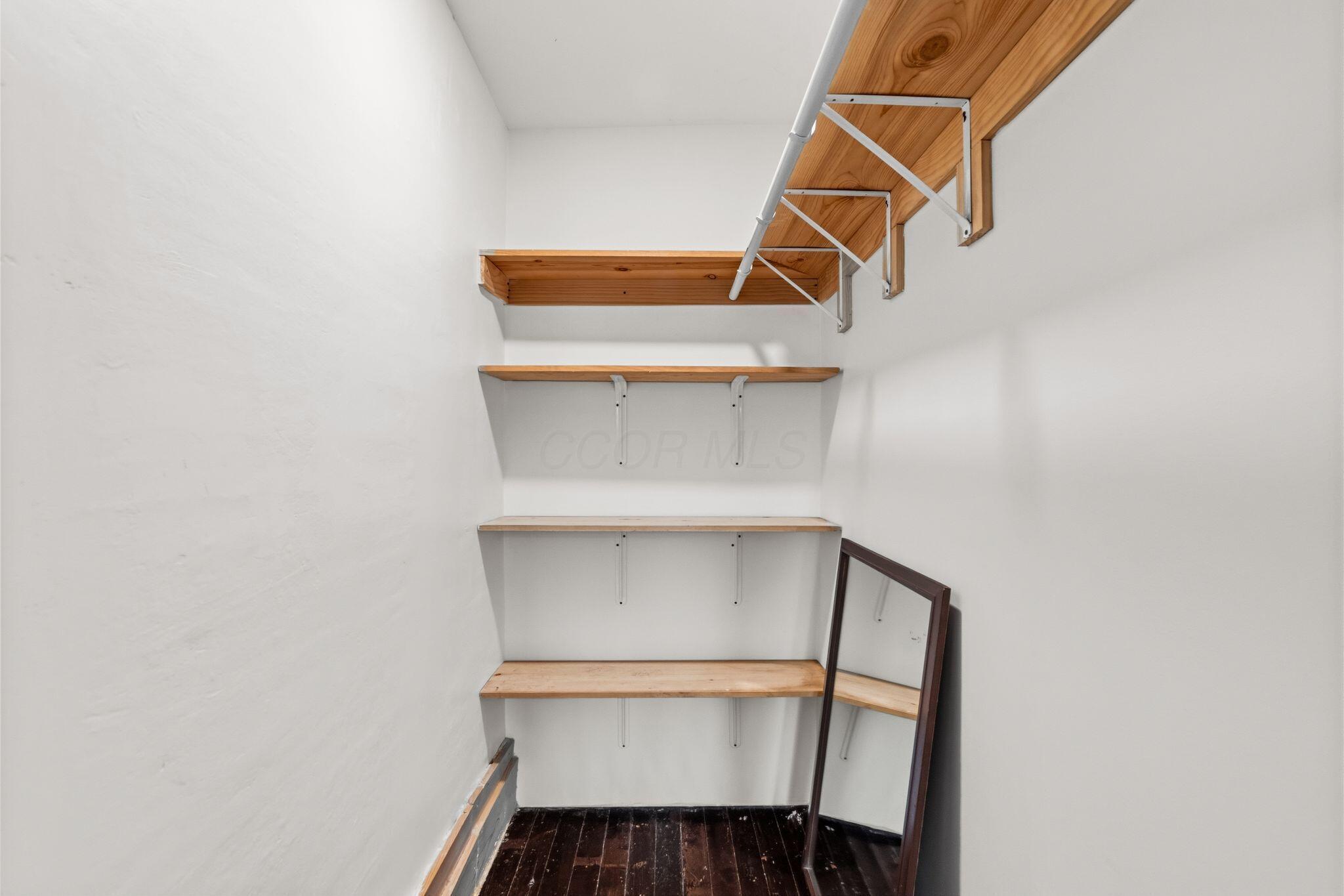107 Price Road Columbus, OH 43230 - Photo 20 of 51 Closet with dark wood-finish flooring, white walls, and multiple levels of natural wood shelving