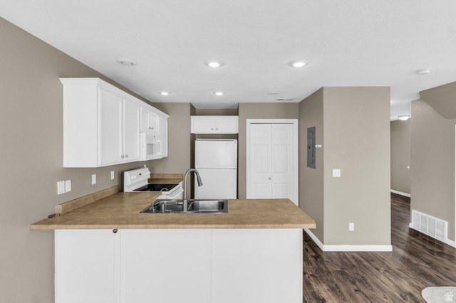 656 South 910 West, Unit 25 Pleasant Grove, UT 84062 - Photo 10 of 25 Open-concept kitchen featuring white cabinetry, light-toned countertops, and a double-basin stainless steel sink with a high-arc faucet.