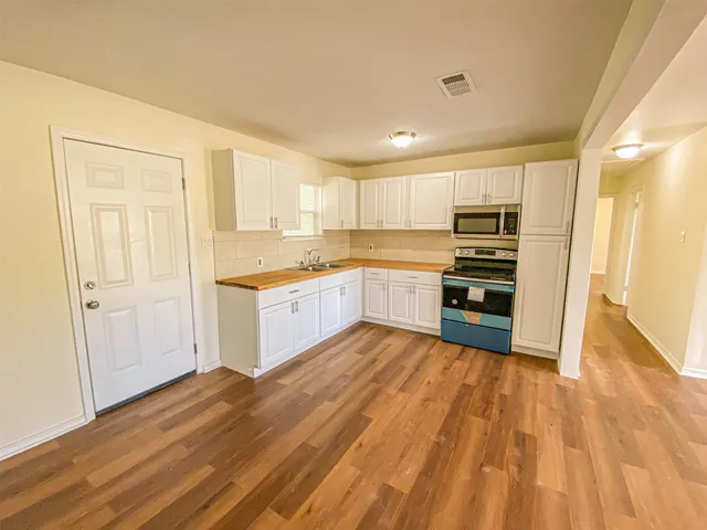 a view of a room with wooden floor and a window