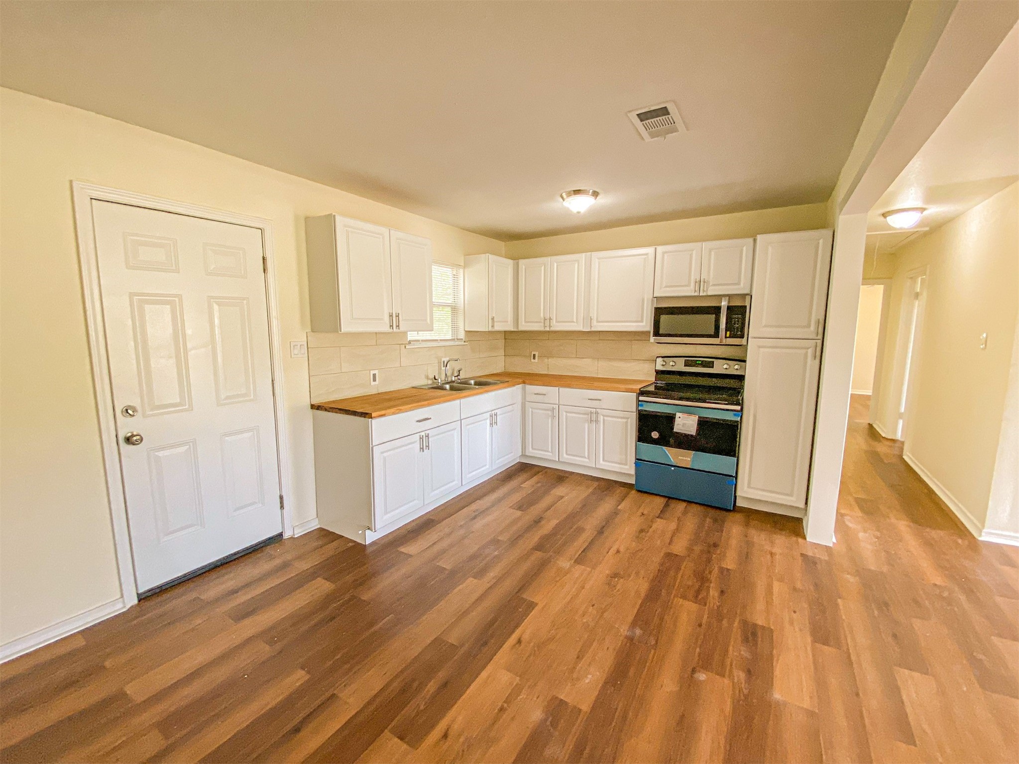 3815 Commerce Street Damon, TX 77430 - Photo 13 of 16 a large kitchen with kitchen island granite countertop wooden floors and white stainless steel appliances