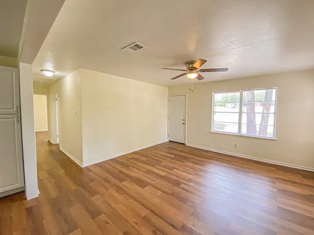 a view of empty room with wooden floor