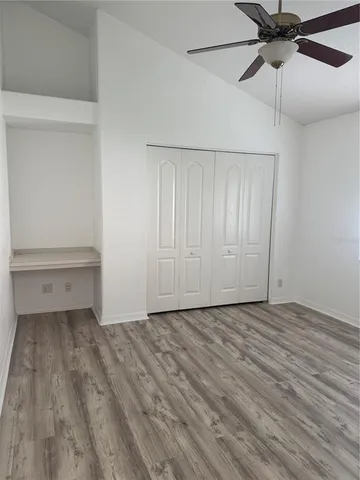 a view of an empty room and chandelier fan
