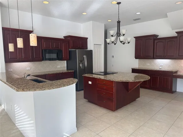 a kitchen with stainless steel appliances granite countertop a sink a stove and a refrigerator