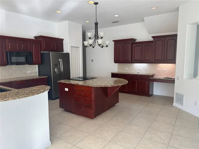 a kitchen with stainless steel appliances granite countertop a refrigerator and a stove