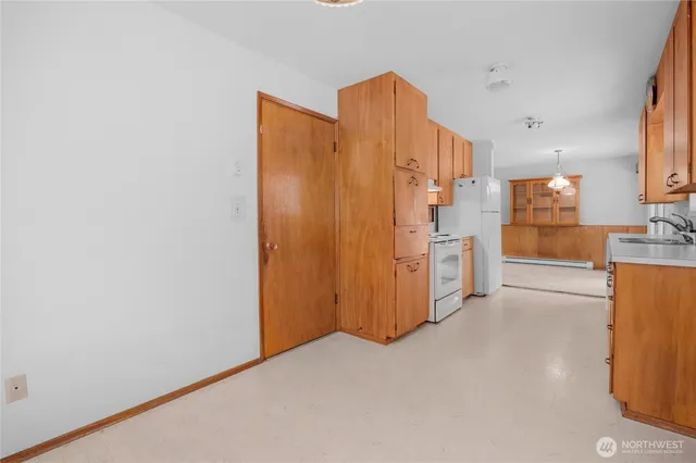 a view of a kitchen with refrigerator and wooden floor