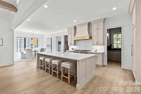 a large kitchen with kitchen island a sink a stove a table and chairs
