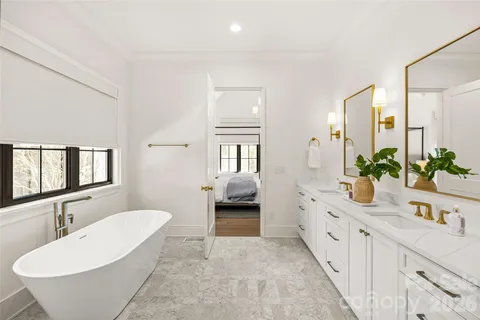 a bathroom with a double vanity sink a mirror and a bathtub