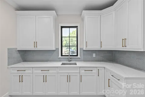 a kitchen with granite countertop white cabinets and sink