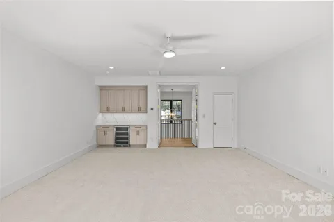 an empty room with a cabinet and a view of kitchen