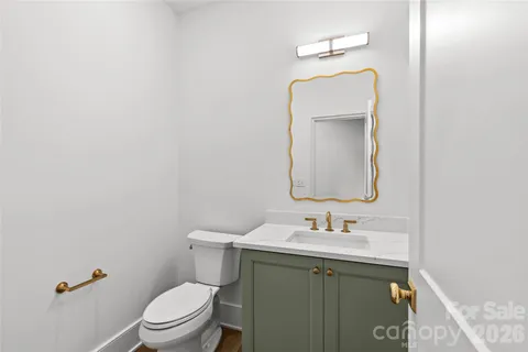 a bathroom with a toilet sink vanity and mirror