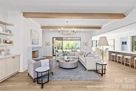 a living room with fireplace furniture and a large window