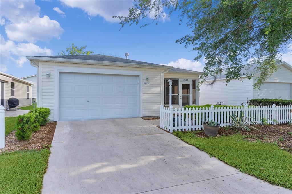 2623 Ascot Loop The Villages, FL 32162 - Photo 28 of 40 a view of a house with a small yard and a large tree