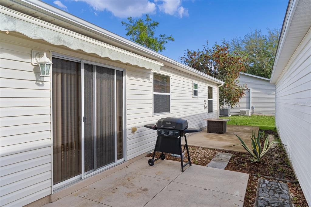 2623 Ascot Loop The Villages, FL 32162 - Photo 32 of 40 a view of backyard with outdoor seating and trees in the background