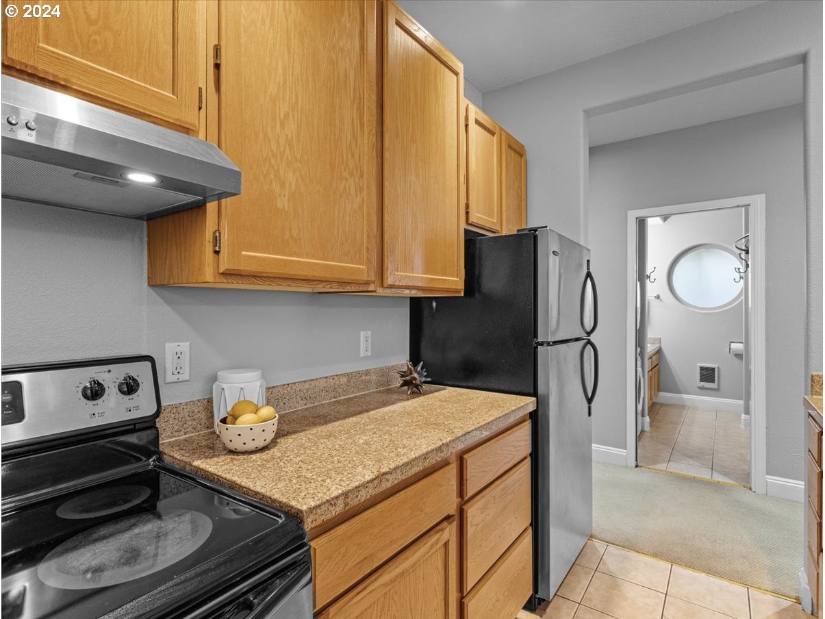 5221 Southwest View Point Terrace, Unit 2 Portland, OR 97239 - Photo 12 of 30 a kitchen with stainless steel appliances granite countertop a refrigerator a stove and a sink with cabinets