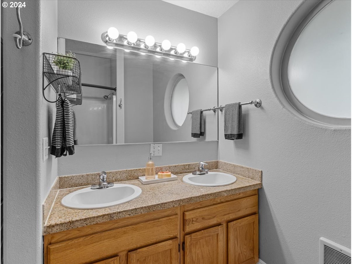 5221 Southwest View Point Terrace, Unit 2 Portland, OR 97239 - Photo 18 of 30 a bathroom with a double vanity sink and a mirror