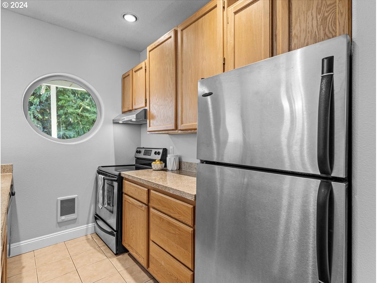 5221 Southwest View Point Terrace, Unit 2 Portland, OR 97239 - Photo 10 of 30 a white refrigerator freezer sitting inside of a kitchen