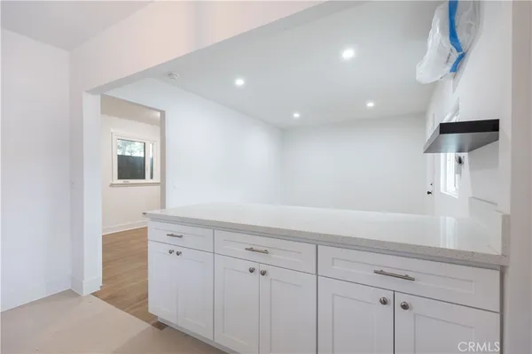 a hallway with white cabinets