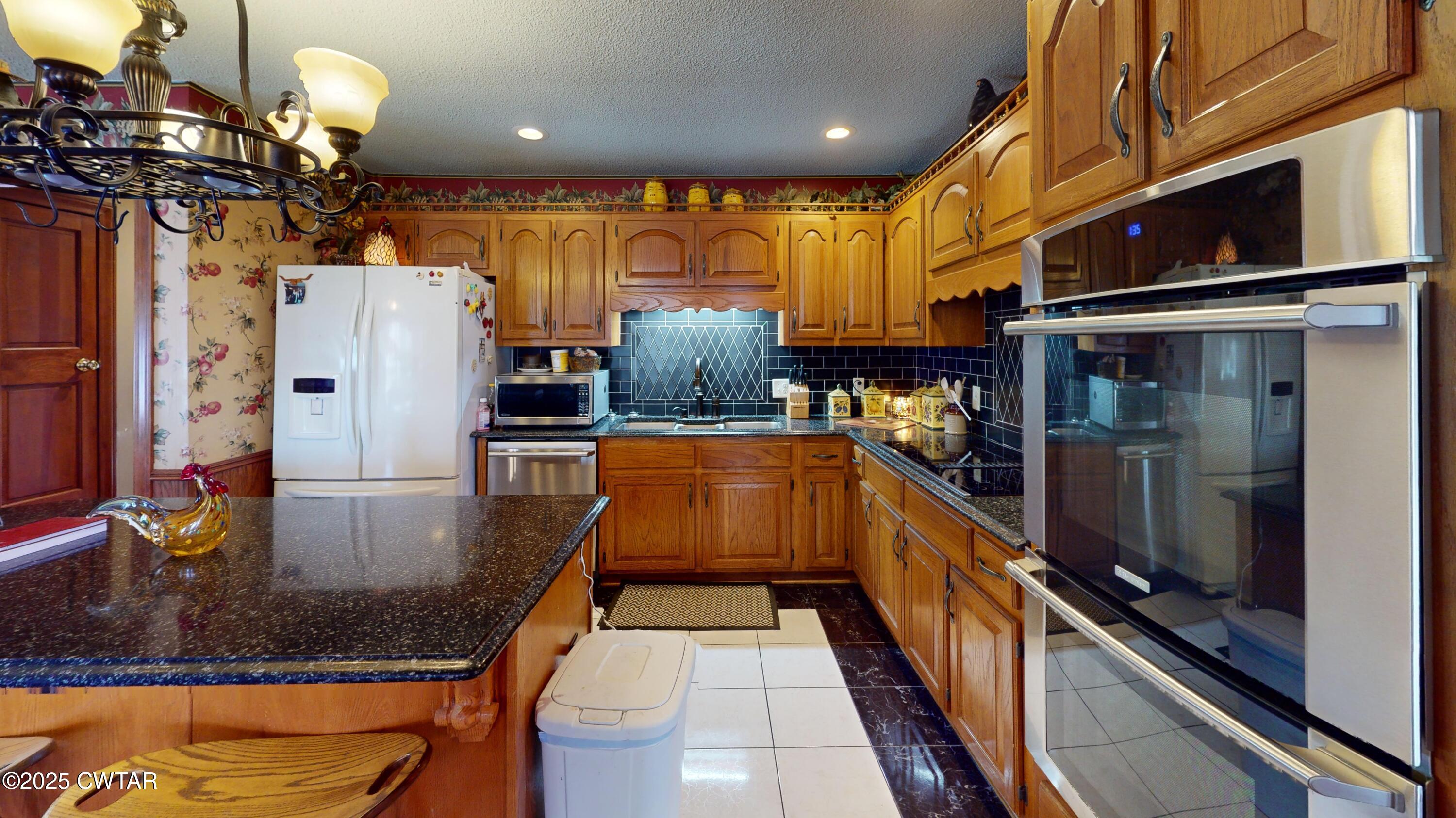 1268 Lightfoot Luckett Road Ripley, TN 38063 - Photo 10 of 40 a kitchen with stainless steel appliances granite countertop a sink a stove and a refrigerator