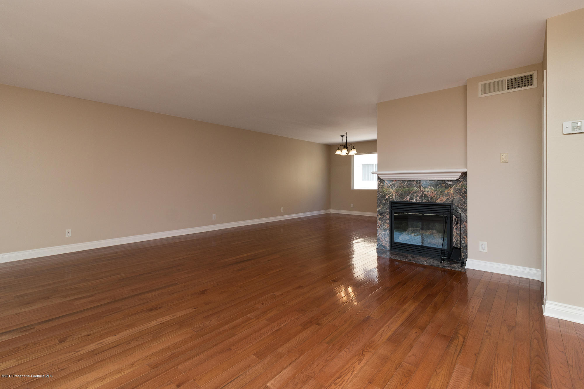 9730 Vía Roma Burbank, CA 91504 - Photo 3 of 24 a view of empty room with wooden floor and fireplace
