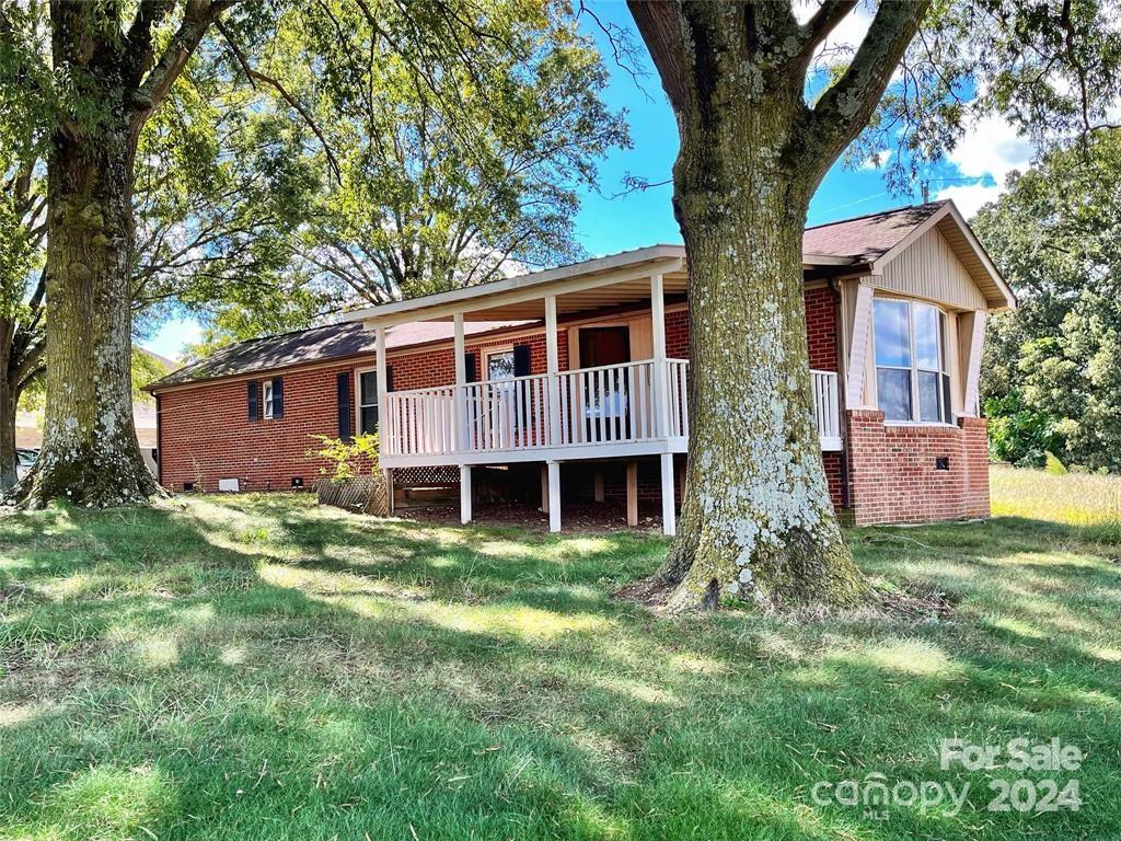 7001 Alexander Farm Road Monroe, NC 28110 - Photo 1 of 14 a view of a yard in front of a house with plants and large tree