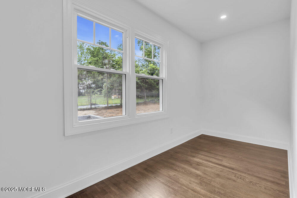 8 Holling Road Colts Neck, NJ 07722 - Photo 22 of 41 a view of empty room with wooden floor and fan