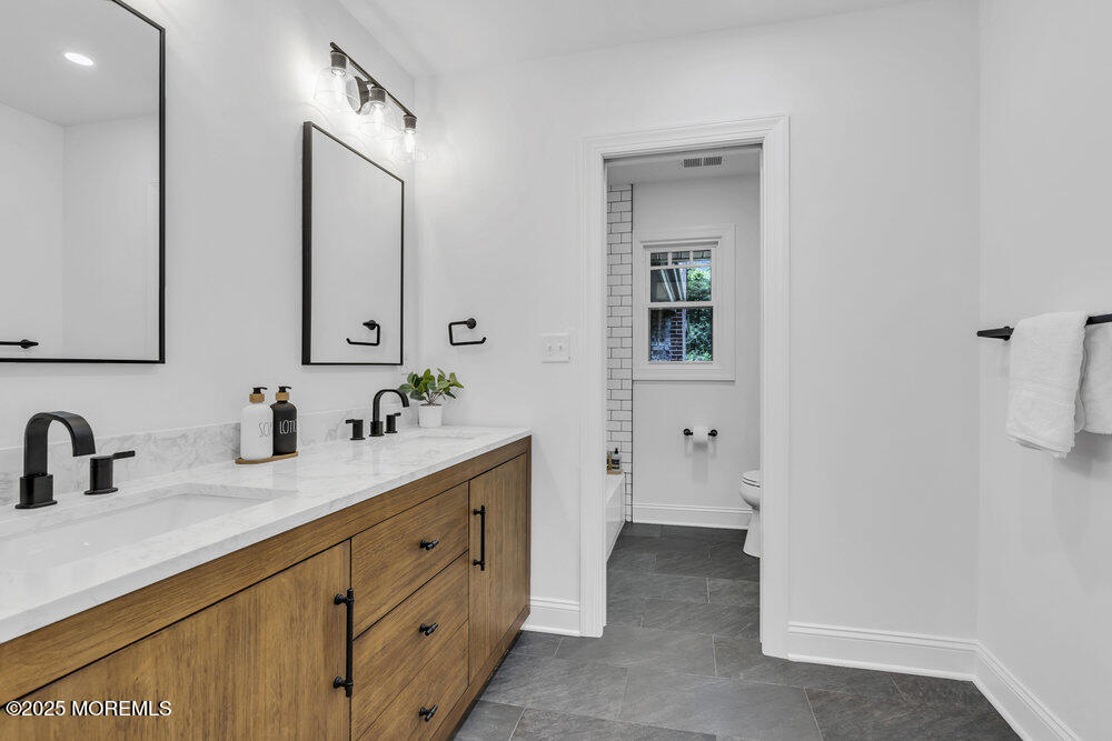 8 Holling Road Colts Neck, NJ 07722 - Photo 23 of 41 a bathroom with a double vanity sink and mirror