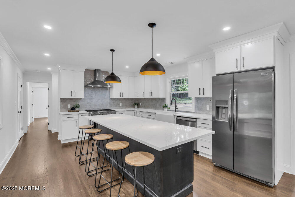 8 Holling Road Colts Neck, NJ 07722 - Photo 4 of 41 a kitchen with granite countertop a sink a stove a refrigerator and a dining table with wooden floor