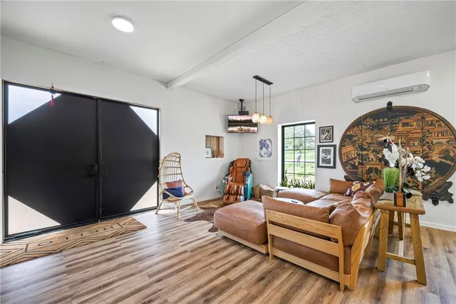 a hallway with a view of living room with a large mirror next to a window