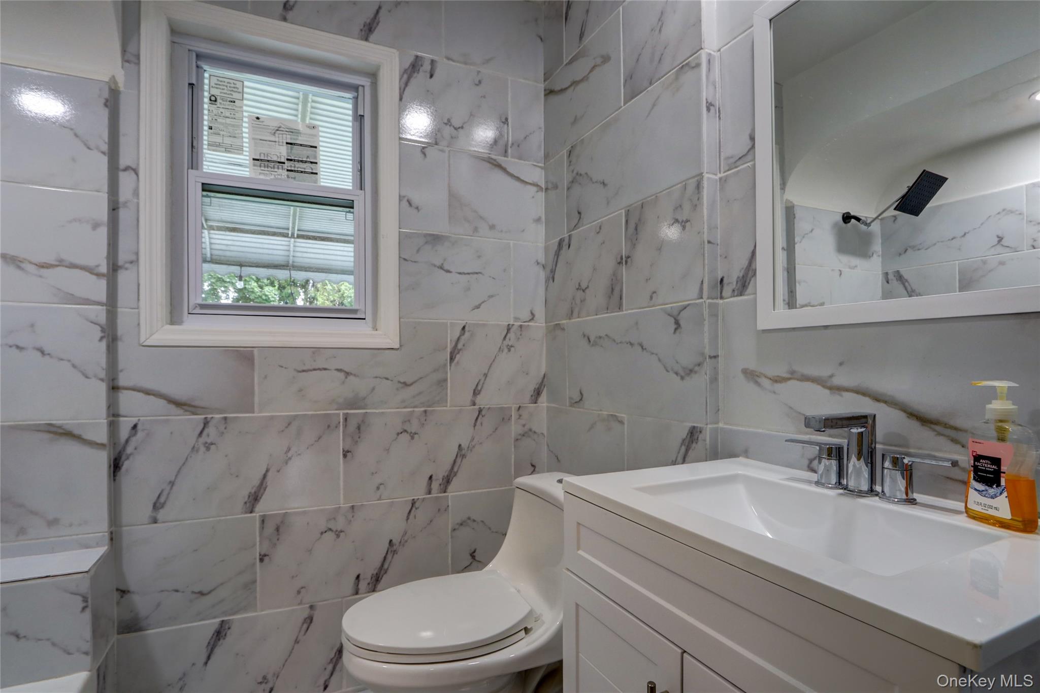 130-55 222nd Street Queens, NY 11413 - Photo 9 of 14 Bathroom with vanity and tile walls