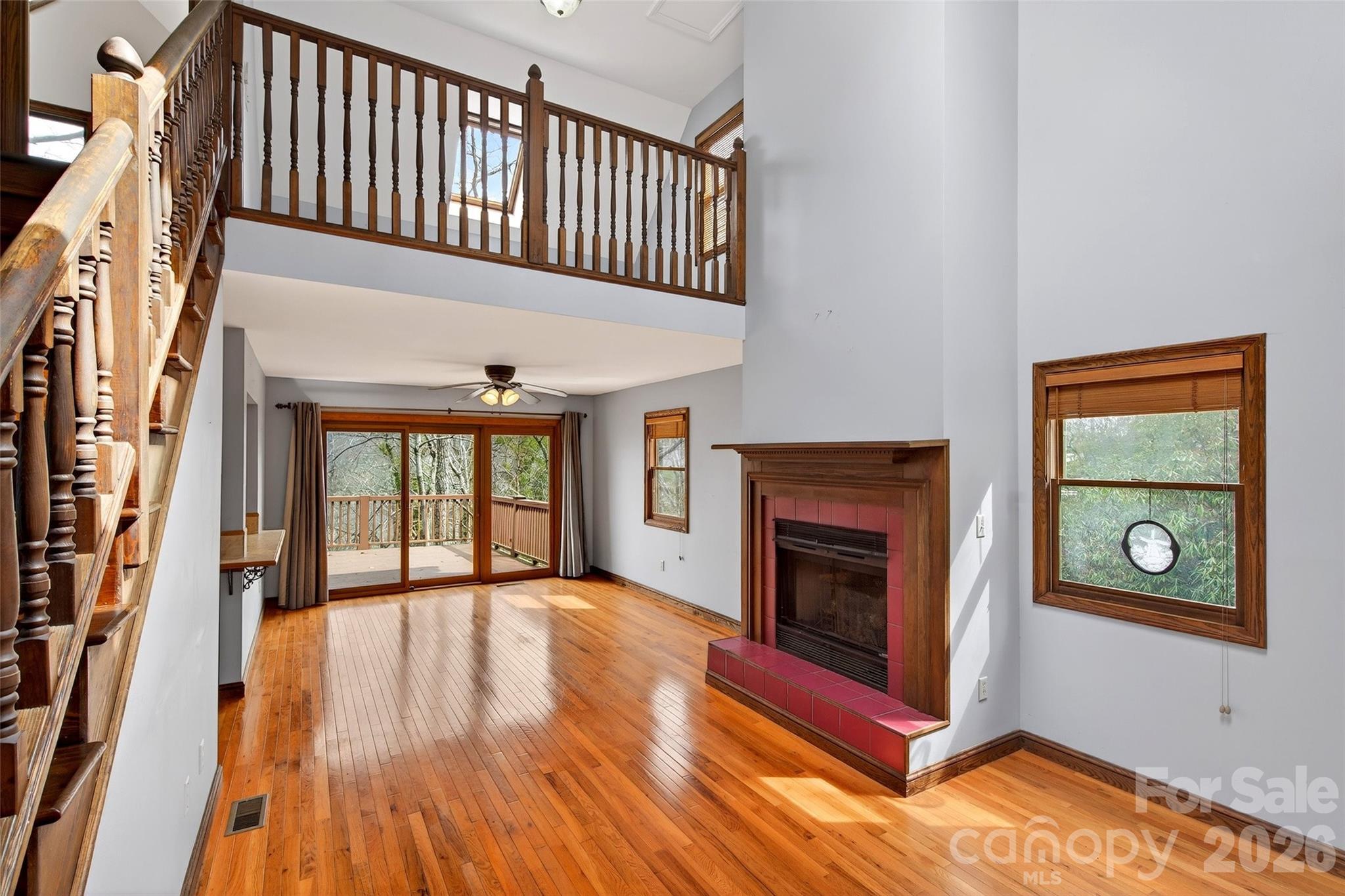 169 Hilltop Road Black Mountain, NC 28711 - Photo 8 of 48 a view of an empty room with wooden floor fireplace and a window