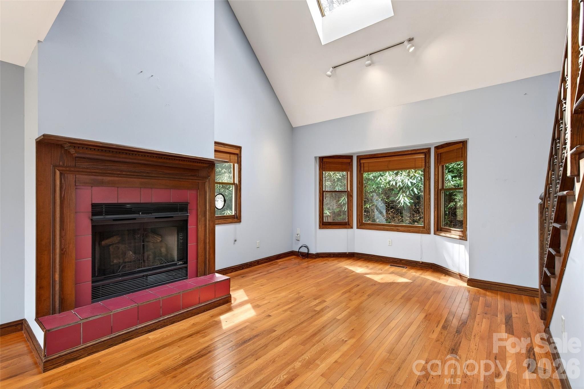 169 Hilltop Road Black Mountain, NC 28711 - Photo 9 of 48 a view of an empty room with wooden floor fireplace and a window