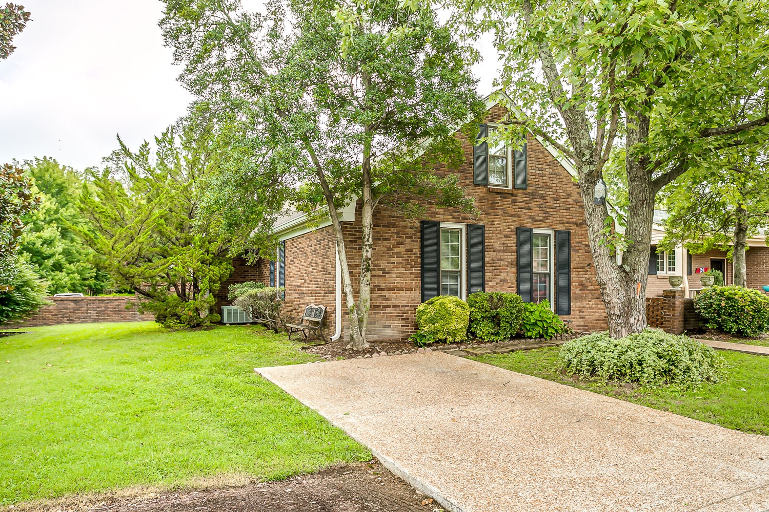 a front view of a house with yard and green space