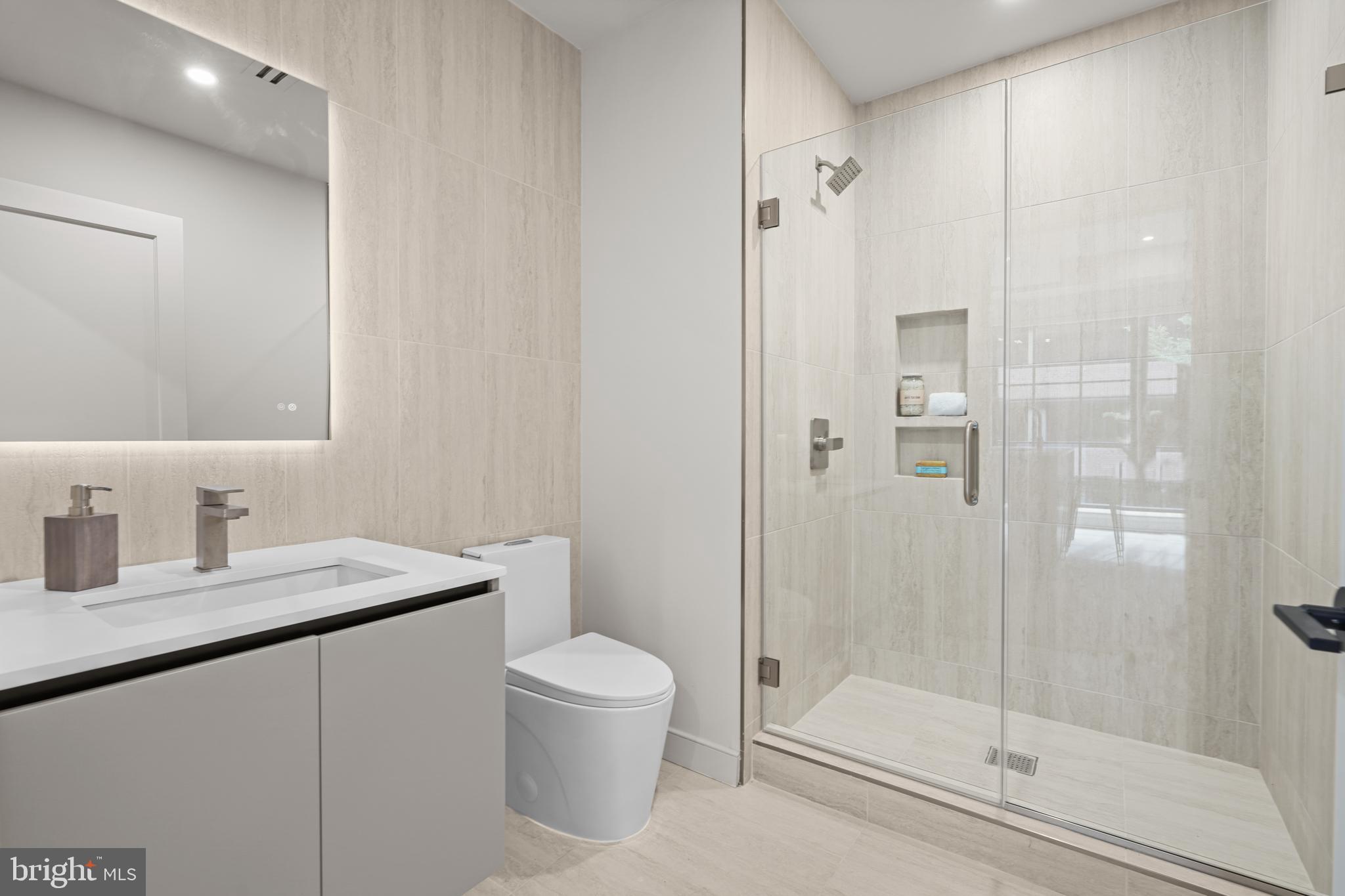 2121 Ward Place Northwest, Unit 405 Washington, DC 20037 - Photo 14 of 20 a bathroom with a granite countertop sink a toilet and shower