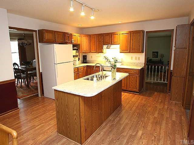 11717 Old Creedmoor Road Raleigh, NC 27613 - Photo 3 of 12 a kitchen with stainless steel appliances a sink a stove a refrigerator and cabinets