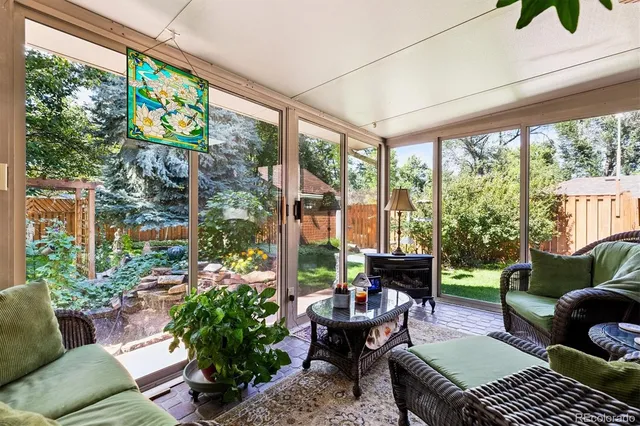 a living room with patio furniture and a potted plant