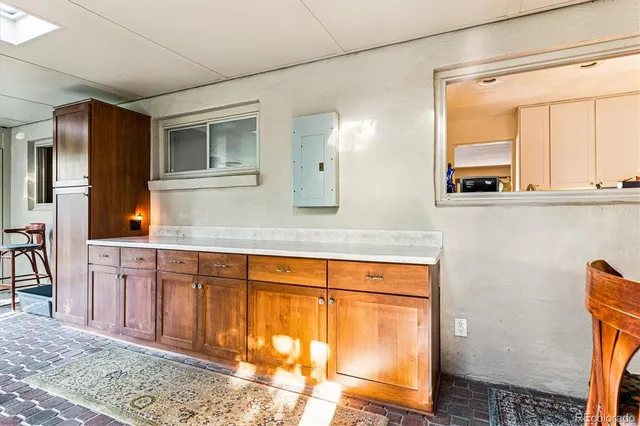 a view of a workspace with furniture and a window